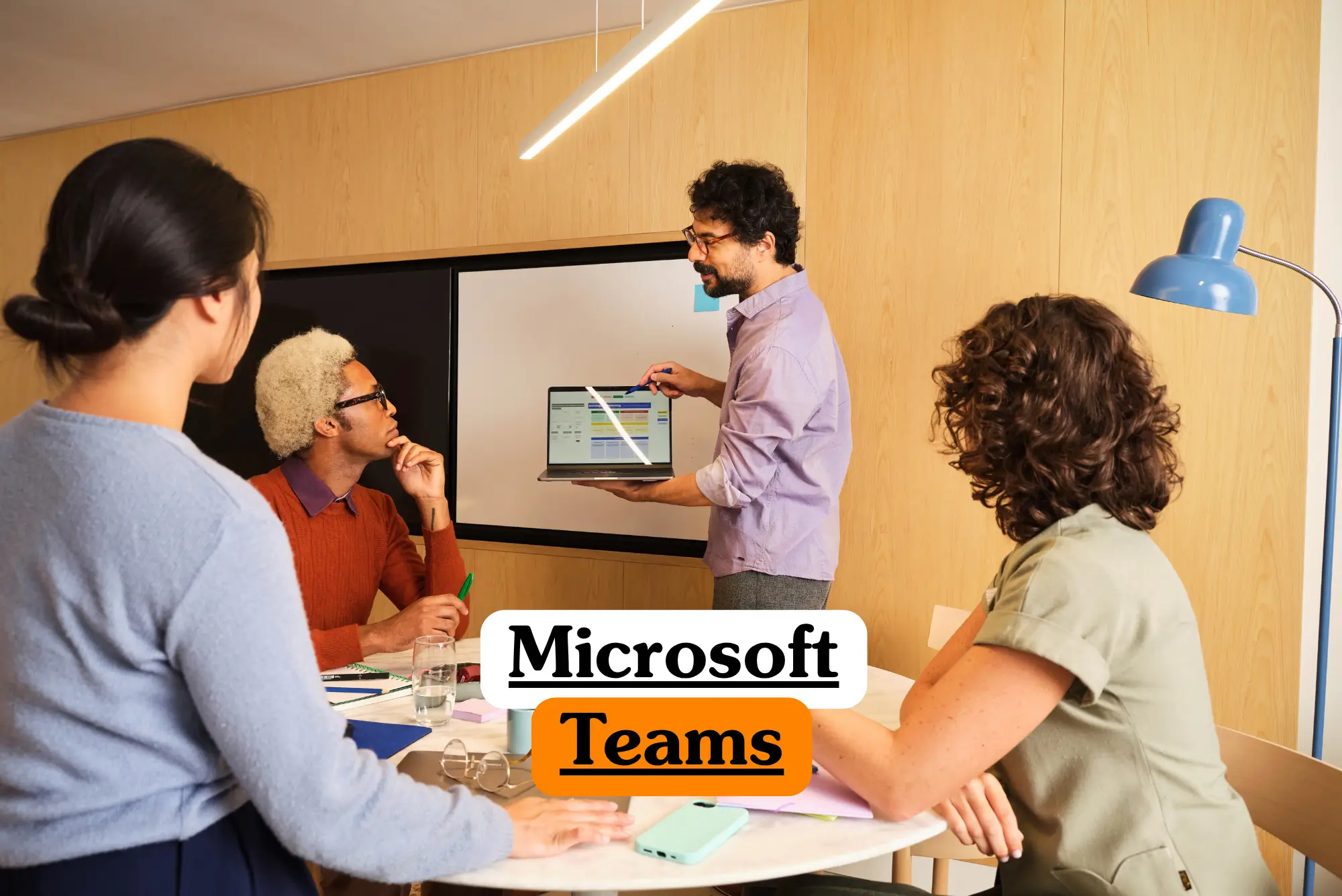 Theoretical enterprise collaboration and unified communications training banner featuring a diverse corporate project team conducting an agile sync meeting around a white round table in a modern office with light wood paneling.