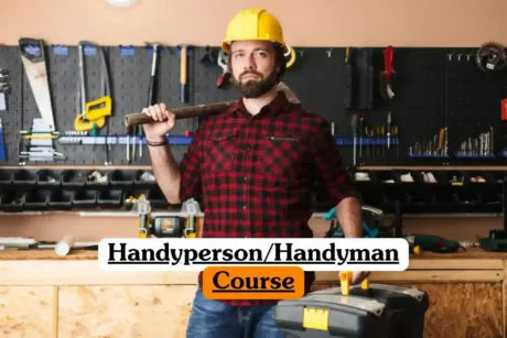 Handyperson Handyman Course banner with person in yellow hard hat red and black checkered shirt holding hammer over shoulder and toolbox with yellow handle standing in workshop with wall mounted tool rack saws screwdrivers wrenches drills and wooden workbench with tools and materials.