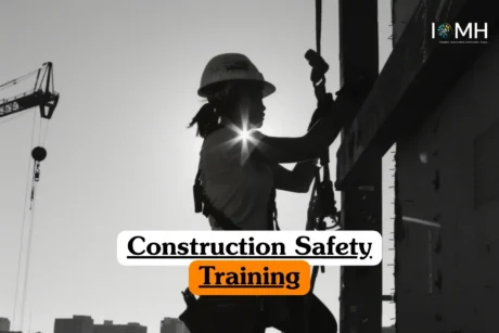 Construction Safety Training course banner with worker in helmet and harness silhouetted against sun with crane and IOMH logo.