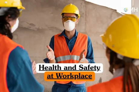 Health and Safety at Workplace course banner with three workers in yellow safety helmets orange reflective vests and protective face masks standing in construction setting with concrete wall background one worker leading safety briefing.