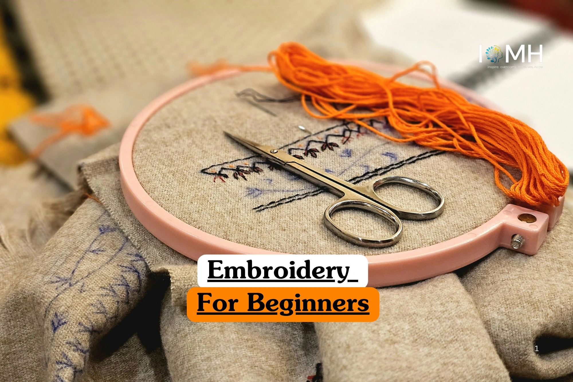 Theoretical textile arts and creative crafting training banner featuring a pink embroidery hoop holding a neutral-coloured fabric with delicate needlework, a pair of silver craft scissors, and a bundle of vibrant orange thread.