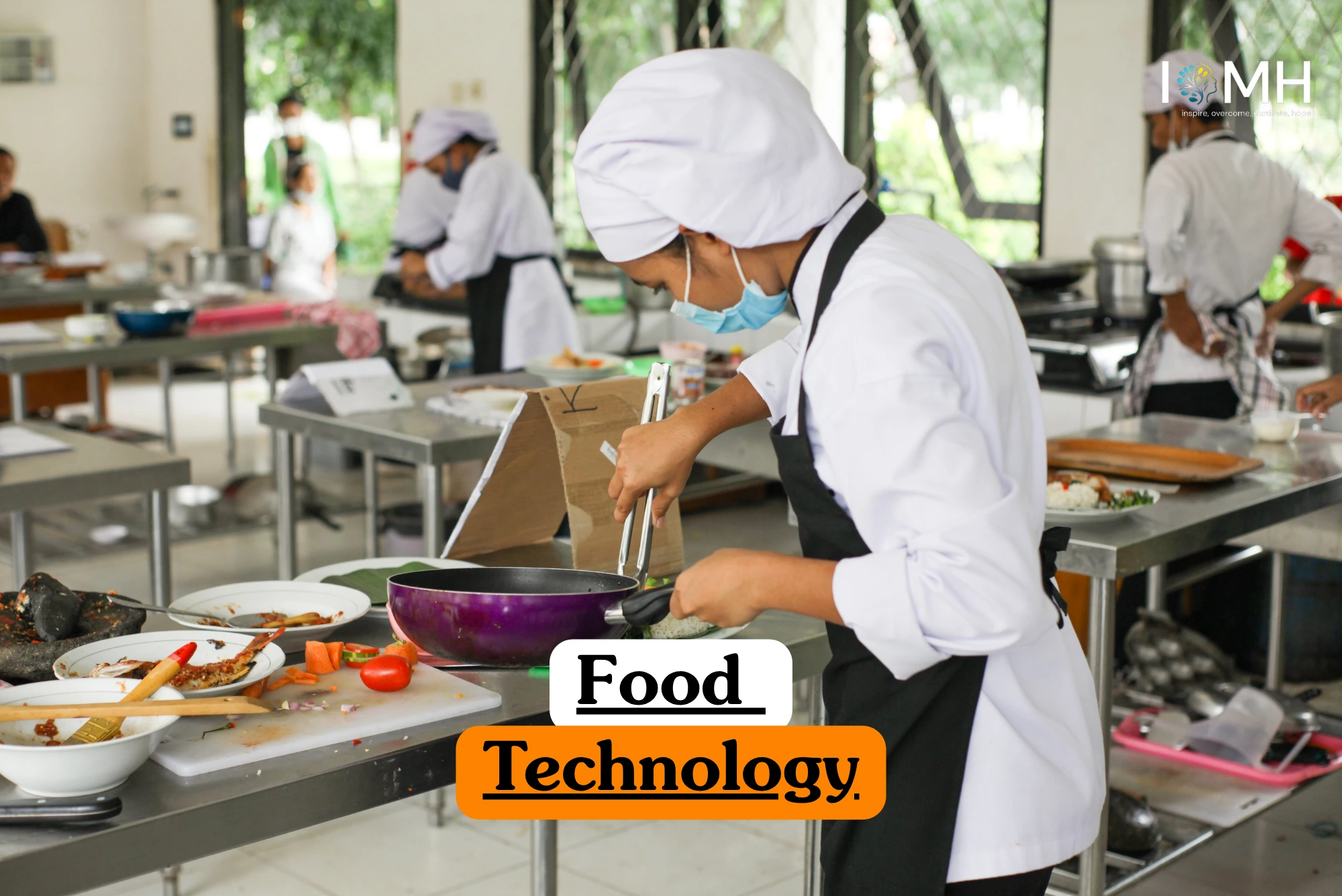 Theoretical food science and production management training banner featuring several students in white chef uniforms, hairnets, and face masks working at stainless steel stations in a large commercial kitchen environment.