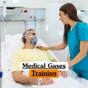 Medical Gases Training course banner with patient in yellow shirt lying in hospital bed wearing oxygen mask connected to medical gas supply assisted by healthcare professional in blue scrubs beside bed with another staff member in white attire in clean clinical environment.