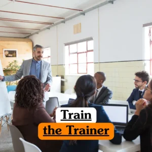 Corporate education training banner featuring a male instructor in a grey blazer writing on a whiteboard while leading a professional workshop for a diverse group of adults in a bright office.