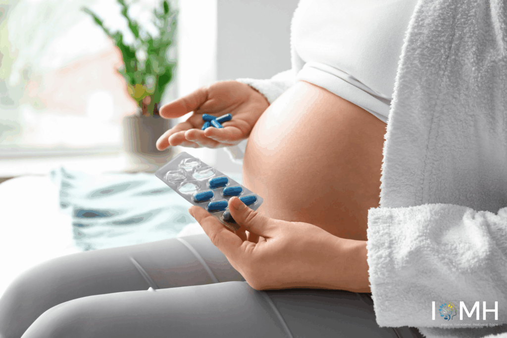 Pregnant woman holding prenatal vitamins and blue capsules while sitting, focusing on pregnancy nutrition and prenatal supplements