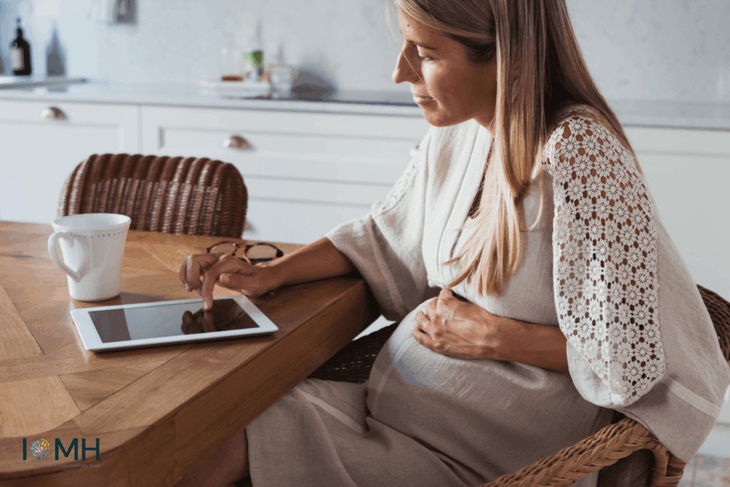 Pregnant woman researching pregnancy tips and prenatal care information on a tablet at home