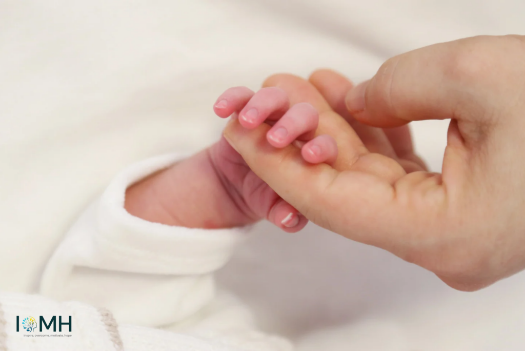 Newborn baby’s tiny hand gently holding an adult’s finger – precious mother-baby bonding moment after pregnancy