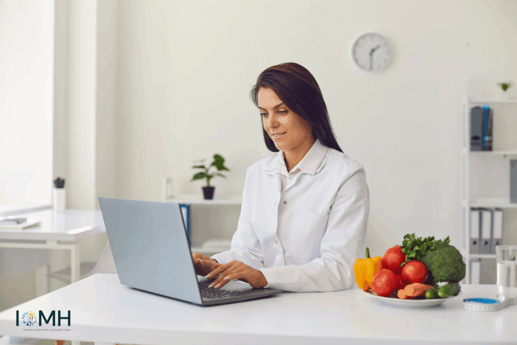 Healthcare professional in a white coat researching nutrition and healthy diet tips on a laptop with fresh vegetables on the desk