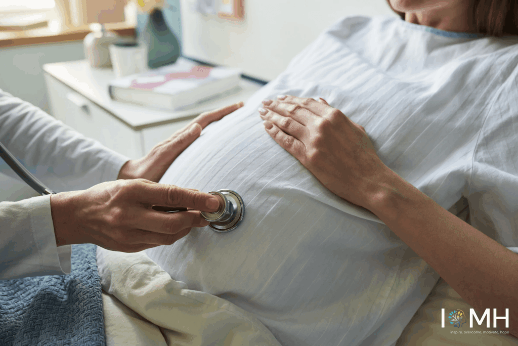 Doctor using a stethoscope to listen to the baby’s heartbeat during a prenatal checkup on a pregnant woman’s belly